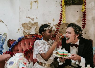 bride feeding groom rainbow cake