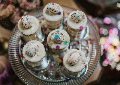 little cakes with rainbow sprinkles on a shiny platter
