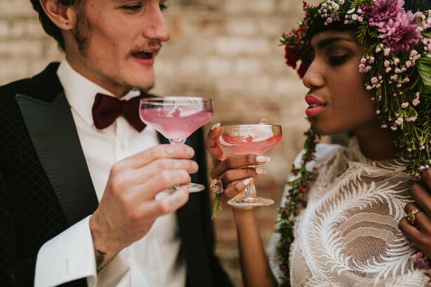 bride and groom cheersing with cocktails
